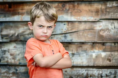 Angry Young Boy With Crossed Arms