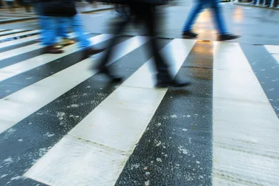 Motion Blur Pedestrians Crossing A Wet Zebra Crossing