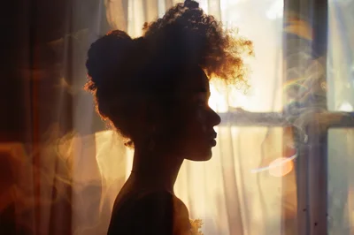 Silhouette Of A Young Woman With Curly Hair