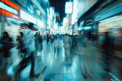 Blurred Commuters Walking Through A Neon Lit City Street