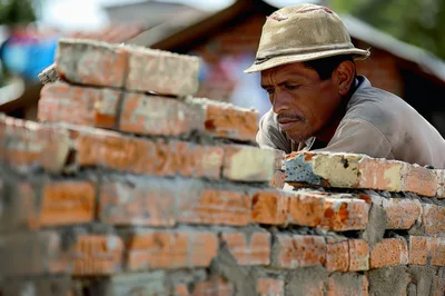 Construction Worker Laying Bricks For A Wall