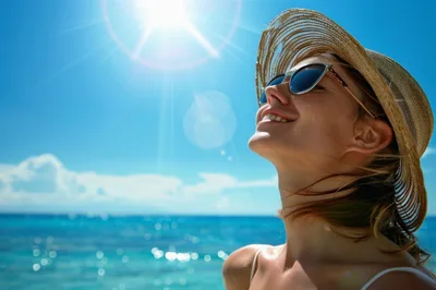 Happy Woman Wearing Straw Hat And Sunglasses At Beach