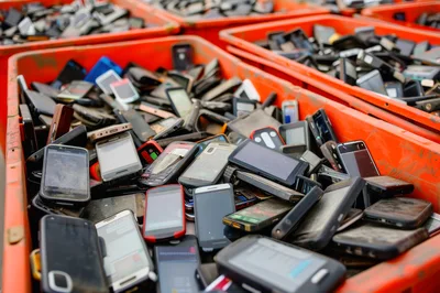 Pile of Discarded Used Mobile Phones in Plastic Bins