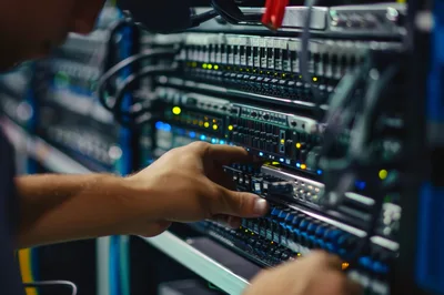 IT Technician Working On Server Rack In Data Center