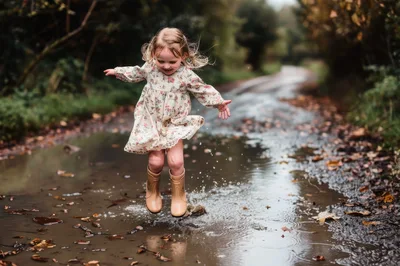 Young Girl Jumping Into A Muddy Puddle