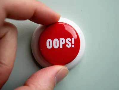 Hand Pressing A Red Oops Button