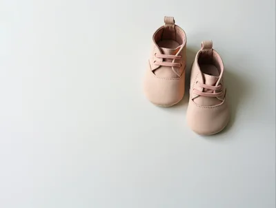 Pair of Soft Pink Baby Shoes on White Background