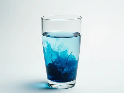 Blue Dye Swirling Inside A Clear Glass Of Water