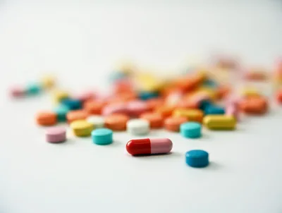 Assorted Colorful Pharmaceutical Pills Scattered on White Surface