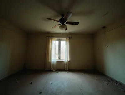 Empty Abandoned Room With Ceiling Fan And Window
