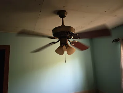 Vintage Ceiling Fan Spinning In A Dimly Lit Room