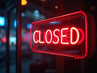 Red Neon Closed Sign Hanging In Store Window