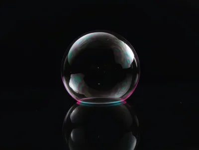 Single Iridescent Soap Bubble On Reflective Black Surface