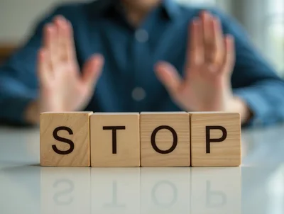 Person Making Stop Gesture Behind Wooden Blocks