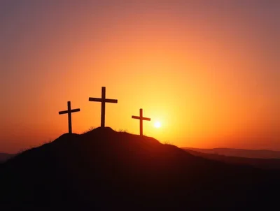 Three Wooden Crosses Silhouetted Against A Vibrant Sunset