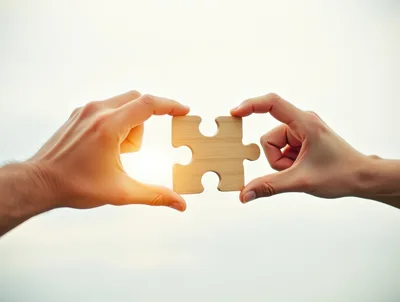 Two Hands Connecting A Wooden Puzzle Piece
