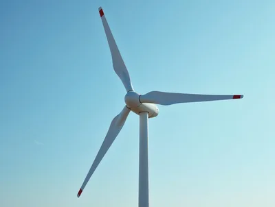 Large Wind Turbine Rotating Against Clear Blue Sky