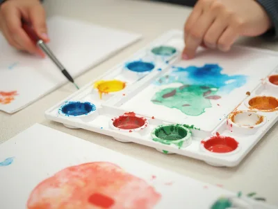 Child Painting With Watercolors On Paper