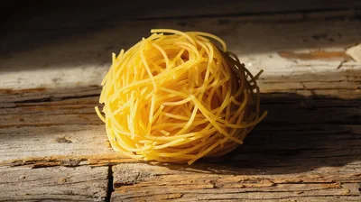 Single Nest Of Raw Pasta On Rustic Wooden Surface