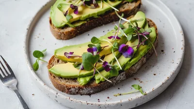 Two Slices Of Avocado Toast With Microgreens And Flowers