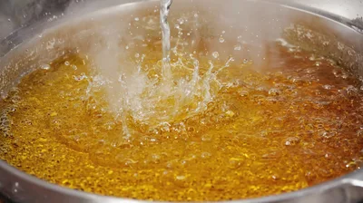 Water Pouring Into Boiling Golden Oil