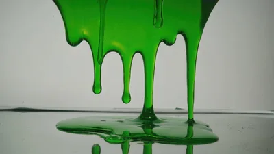Green Slime Dripping Down Onto A Reflective Surface