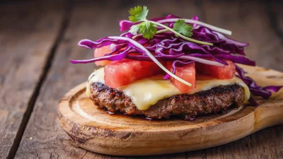 Gourmet Beef Burger Patty With Toppings On Wooden Board