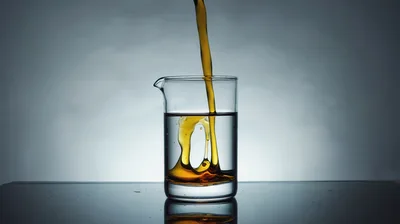 Golden Liquid Pouring Into A Glass Beaker