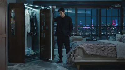 Young Man Selecting Clothes From Modern Smart Wardrobe