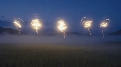 Light Painting Orbs Floating Over Misty Field