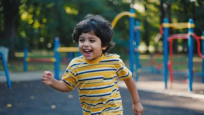 Happy Young Boy Running Through A Playground