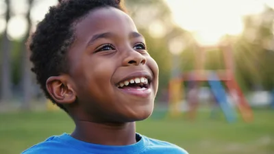 Happy Young Boy Smiling Outdoors at Playground