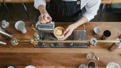 Barista Pouring Latte Art Into A Coffee Cup