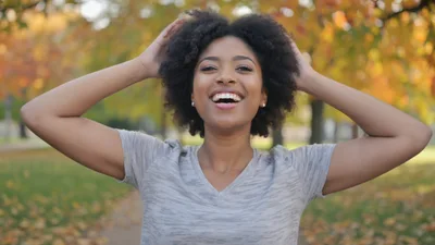 Happy Young Woman With Afro Hair In Autumn Park