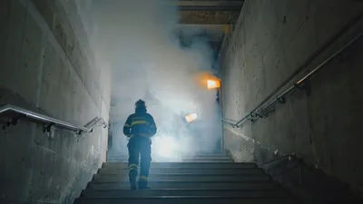 Firefighter Walking Up Stairs Into Thick Smoke