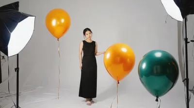 Young Woman Posing With Balloons In Professional Photo Studio