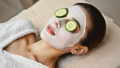 Woman Relaxing With Cucumber Slices And Facial Mask