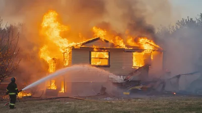 Firefighter Extinguishing A Burning Residential House