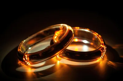 Two Interlocking Gold Wedding Rings With Glowing Light Effects