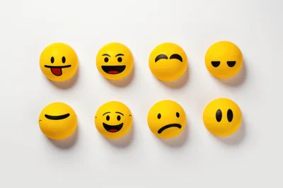 Eight Yellow Emoji Stress Balls On White Background