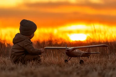 Toddler Playing With Toy Airplane At Sunset