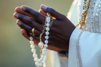 Close Up Of Hands Holding A Pearl Rosary