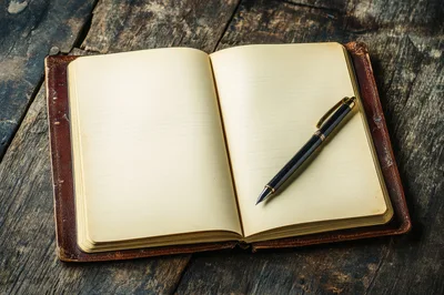 Open Leather Journal With Fountain Pen On Wooden Table