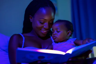 Mother Reading Bedtime Story To Baby