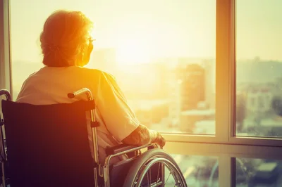 Elderly Woman Sitting In Wheelchair Looking Out Window