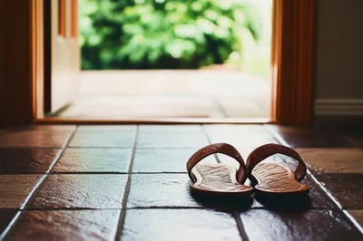 Pair Of Brown Leather Sandals On Tiled Floor