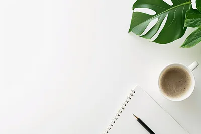 Top View Of Notebook With Coffee And Monstera Leaf