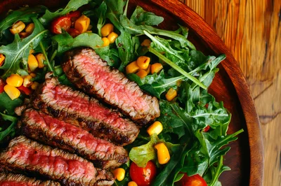 Grilled Steak Slices Served Over Fresh Arugula Salad