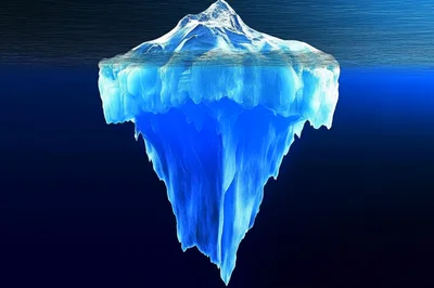 Large Iceberg Floating In Deep Blue Ocean Water