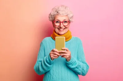 Senior Woman Using Smartphone Against Pink Background